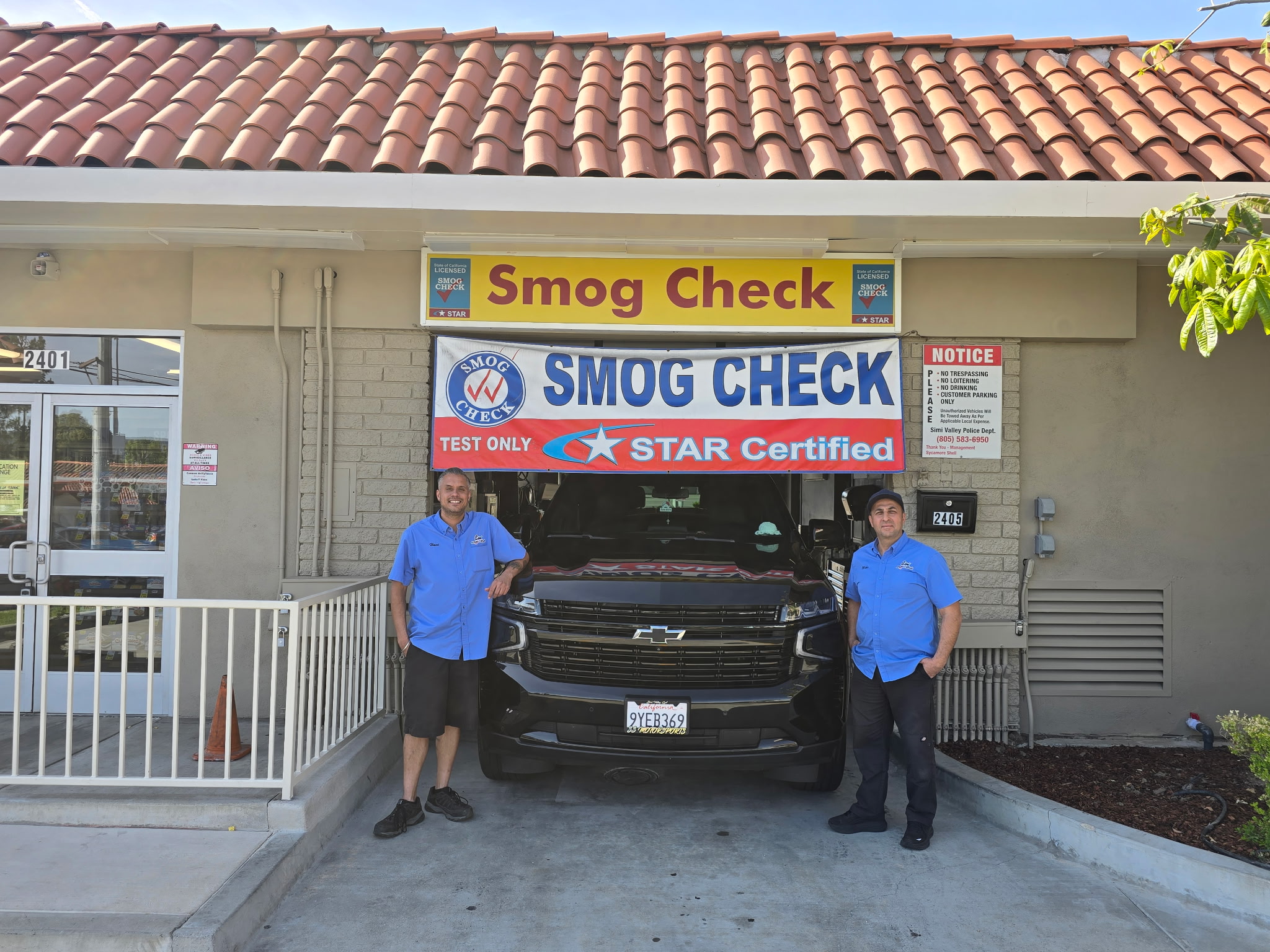 Simi Smog & Wash team — two technicians in blue uniforms at the Sycamore Drive shop