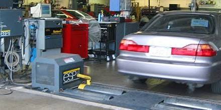 A used car undergoing a smog check on the dynamometer at a California smog station before sale